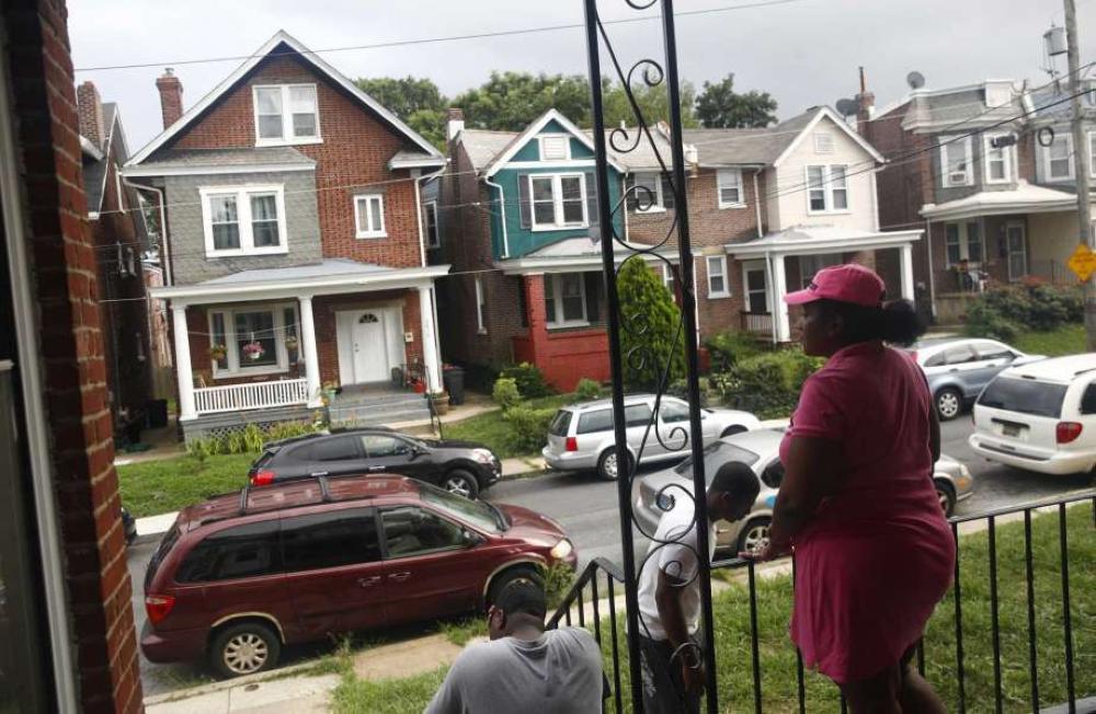 In this July 27, 2017 photo, Maria Williams stands on her front porch in Wilmington, Delaware, the day after her teenage son and daughter were shot and wounded while standing on the same porch. As she took cover inside and heard her kids' screams, 