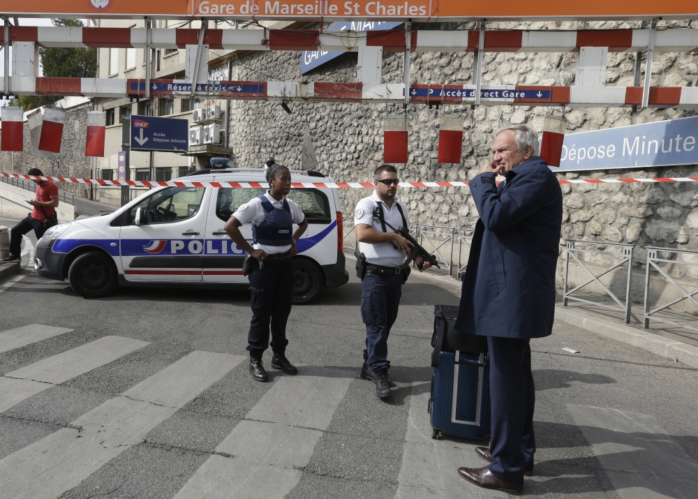A passenger waits Marseille’s main train station as French police officers patrol in Marseille, southern France, on Sunday. — AP