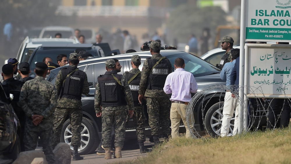 Security officials escort a vehicle carrying sacked Pakistani Prime Minister Nawaz Sharif as he arrives to appear before an accountability court to face corruption charges in Islamabad on Monday. — AFP