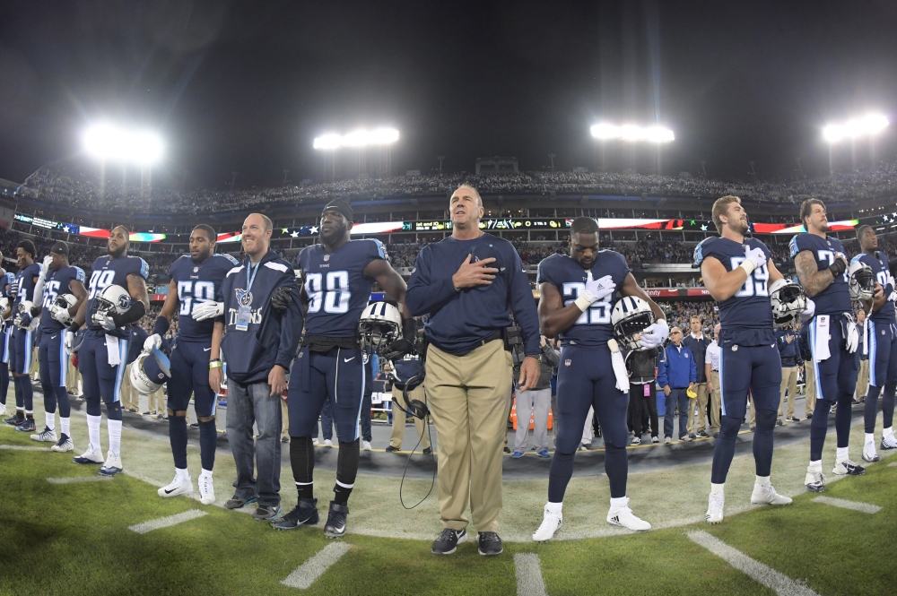 Tennessee Titans head coach Mike Mularkey stands with Titans players during the playing of the national anthem before an game against the Indianapolis Colts at Nissan Stadium. — Reuters