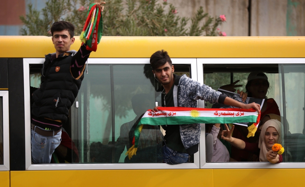 Iraqi Kurds wave fabrics with the color of the Kurdish flag during a protest in support of the Iraqi Kurdish leader in Irbil, the capital of autonomous Iraqi Kurdistan. — AFP