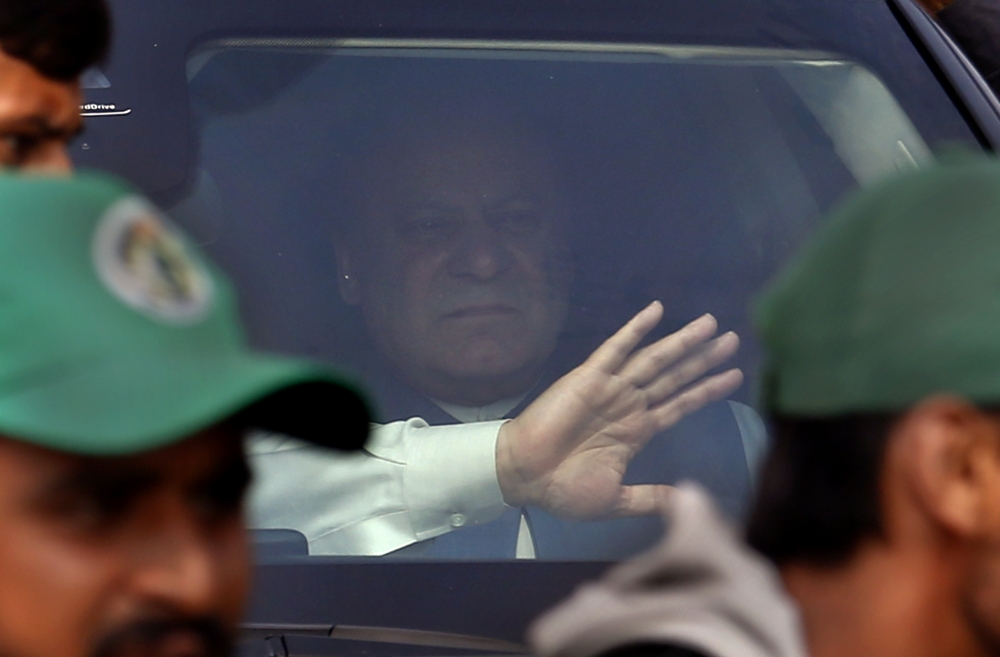 Pakistan’s former Prime Minister Nawaz Sharif waves to supporters from a vehicle while he leaves after appearing in an accountability court to face a trial, in Islamabad, Pakistan, on Tuesday. — AP