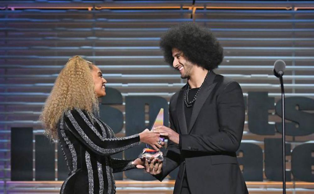 Colin Kaepernick receives the SI Muhammad Ali Legacy Award from Beyonce at the Sports Illustrated Sportsperson of the Year Show. — AFP