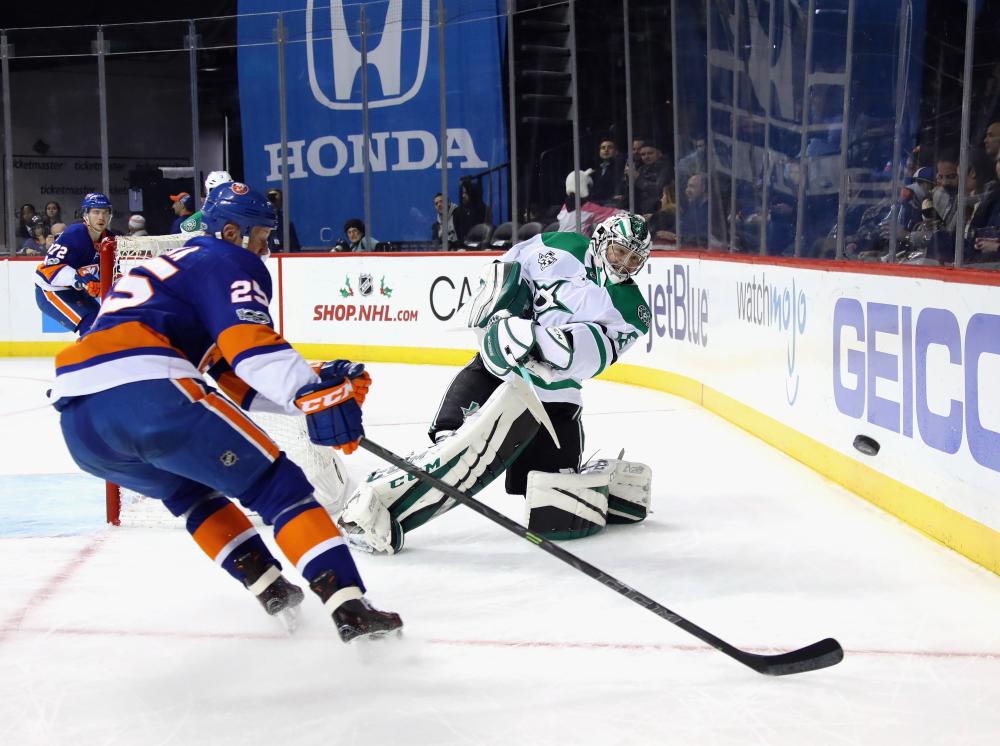 NEW YORK, NY - DECEMBER 13: Kari Lehtonen #32 of the Dallas Stars shoots the puck away from Jason Chimera #25 of the New York Islanders during the second period at the Barclays Center on December 13, 2017 in the Brooklyn borough of New York City.   Bruce Bennett/Getty Images/AFP
== FOR NEWSPAPERS, INTERNET, TELCOS & TELEVISION USE ONLY ==
