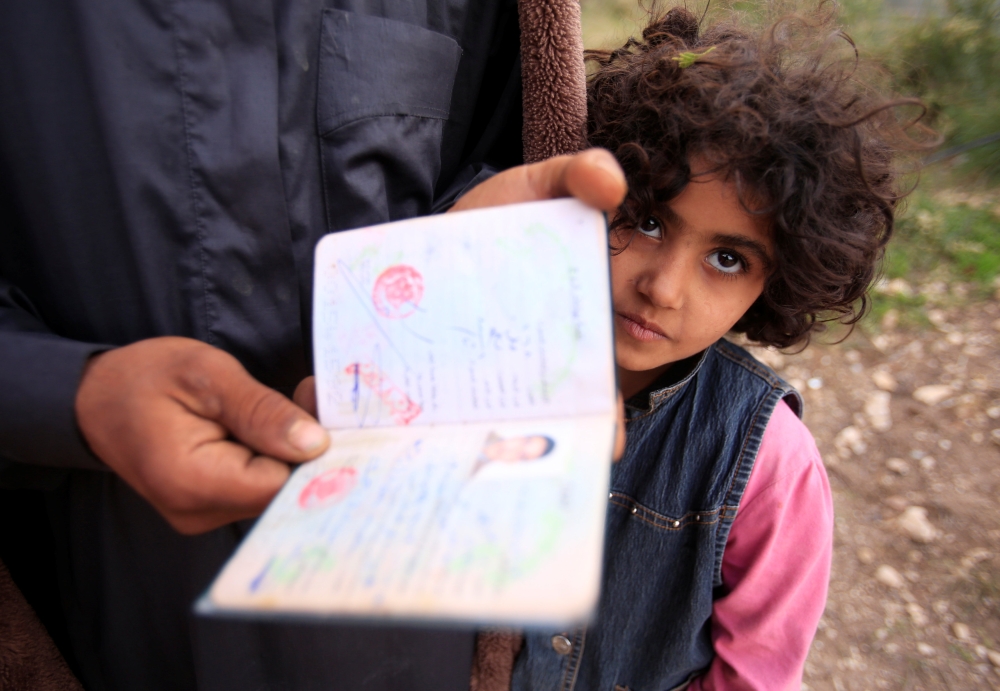 A Syrian refugee man holds a document in Ain Baal village, near Tyre in southern Lebanon. — Reuters