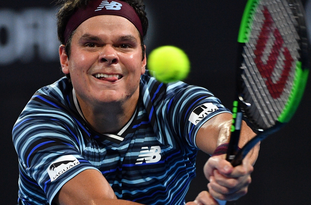 Milos Raonic of Canada hits a return against Alex De Minaur of Australia during their men's singles second round match at Pat Rafter Arena during the Brisbane International tennis tournament in Brisbane on January 3, 2018. IMAGE RESTRICTED TO EDITORIAL USE - STRICTLY NO COMMERCIAL USE
 / AFP / SAEED KHAN / IMAGE RESTRICTED TO EDITORIAL USE - STRICTLY NO COMMERCIAL USE
