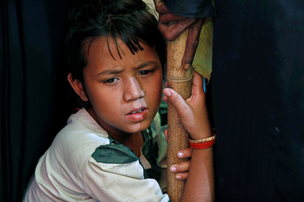 A Rohingya refugee girl reacts as she waits for a medical check-up at Kutupalong refugee camp, near Cox's Bazar, Bangladesh on Friday. — Reuters