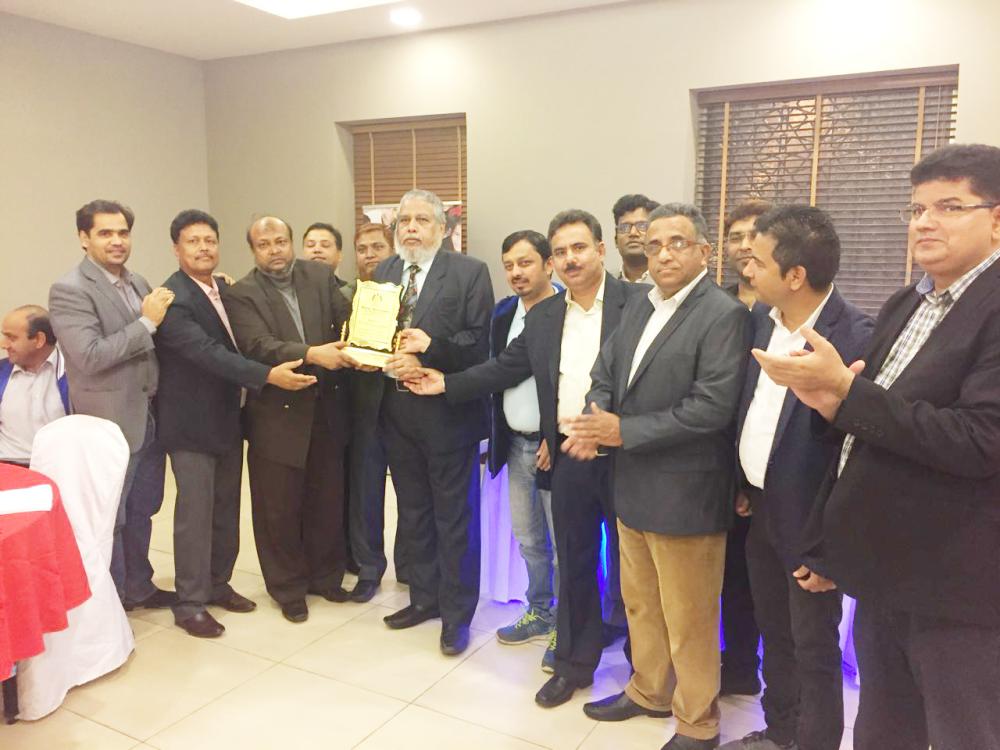 Syed Rashique Ahmad, with the plaque, is honored by Indian groups in the Eastern Province at a farewell dinnier. — Courtesy photo
