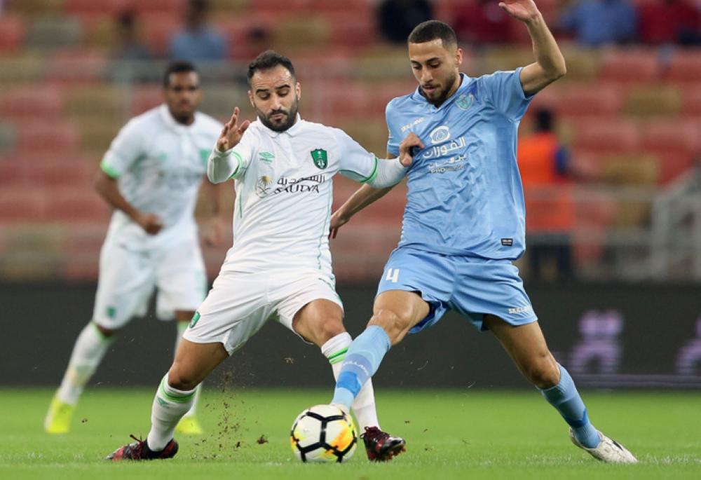 Al-Ahli's Giannis Fetfatzidis (L) vies for the ball with Al-Batin's Maan Khodari during their football match in the Saudi Pro League at the King Abdullah Sports City in Jeddah on Friday —AFP