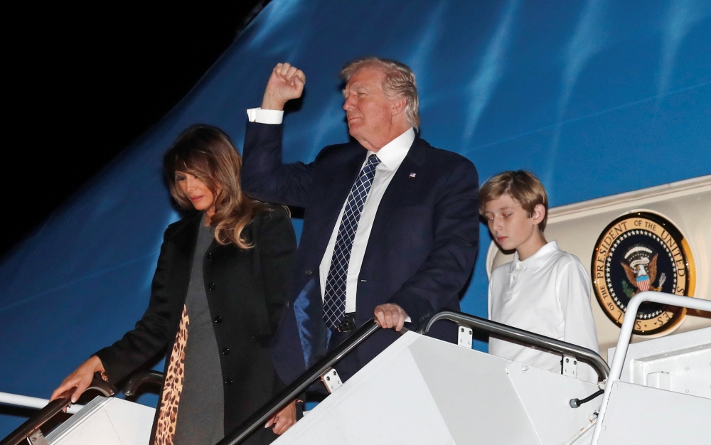 US President Donald Trump, first lady Melania Trump and their son Barron step out from Air Force One upon their arrival in West Palm Beach, Florida, US, on Friday. — Reuters
