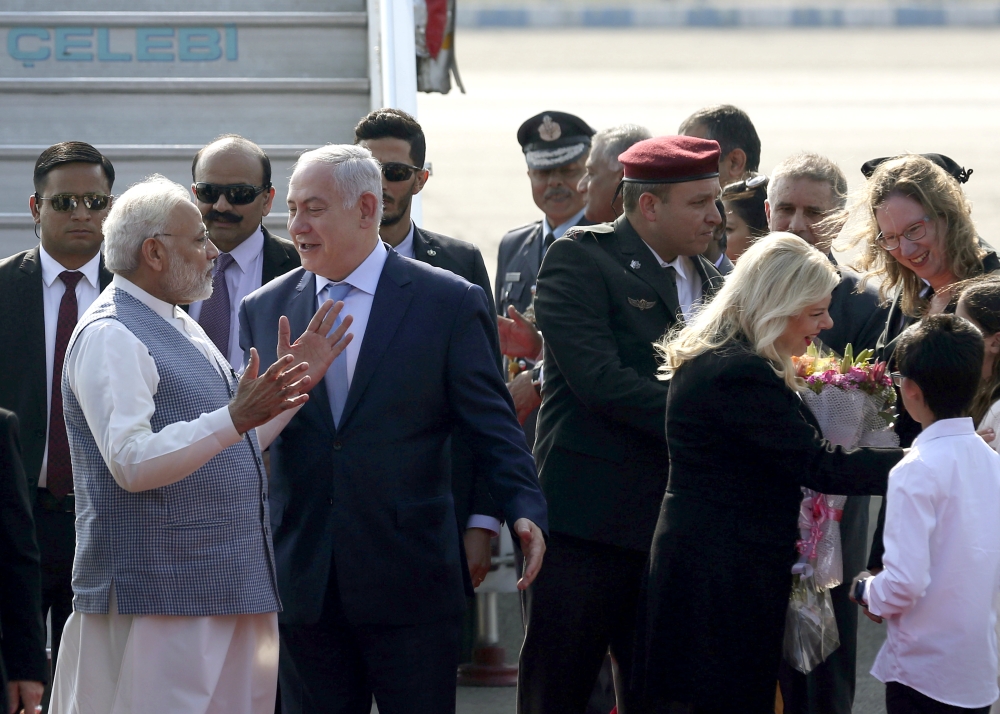 Israel's Prime Minister Benjamin Netanyahu, second from left, talks with India's Prime Minister Narendra Modi as Netanyahu and his wife Sarah, second from right, arrive at Palam airport in New Delhi Sunday. Netanyahu arrived  for his first visit to India to expand defense, trade and energy ties. — AP