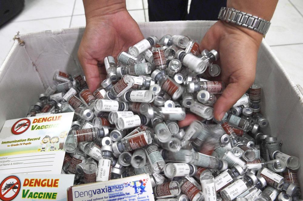 A medical worker displays used vials of Sanofi's dengue vaccine Dengvaxia in the district of Manila, following the suspension of the country's public dengue immunization program. French manufacturer Sanofi is to pay back the Philippine government for unused doses of an anti-dengue vaccine after it was suspended due to health concerns, the two parties said Monday. — AFP