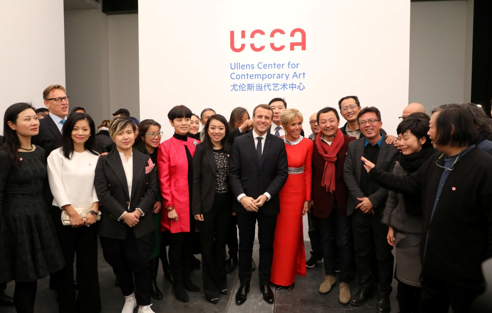 French President Emmanuel Macron (C/L) and his wife Brigitte (C/R) pose with artists as they visit The Ullens Chinese Contemporary Art Center in Beijing, China. — Reuters