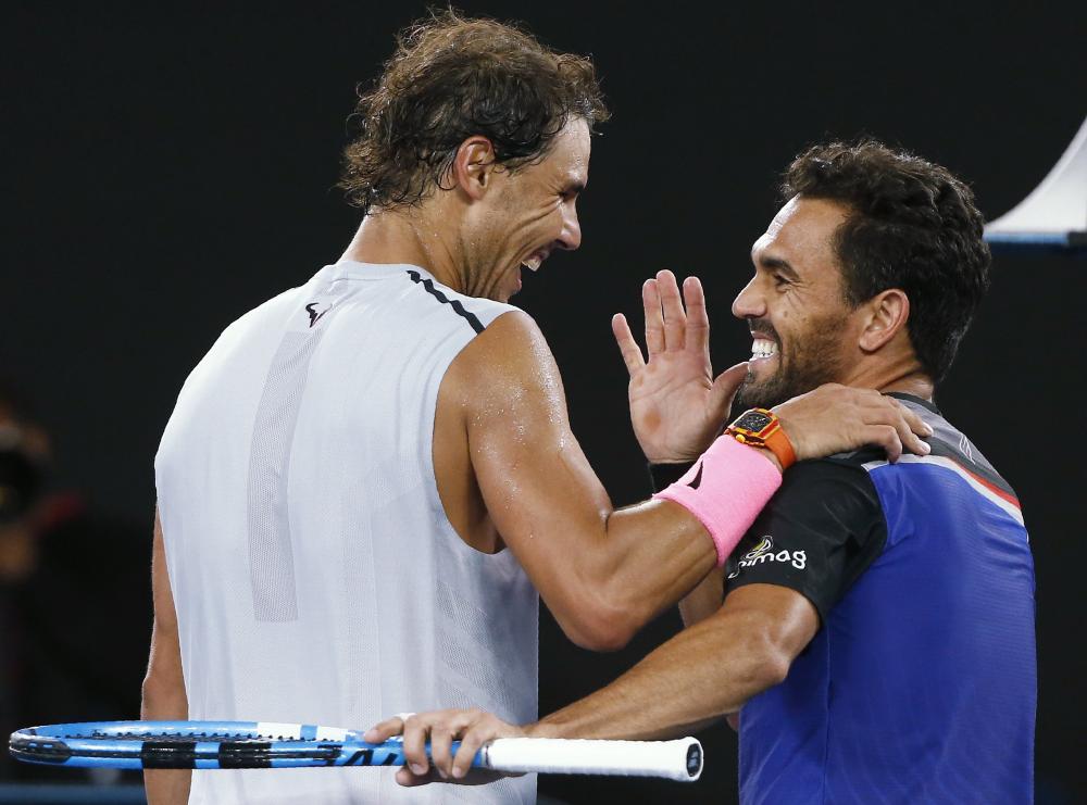 Rafael Nadal of Spain (L) and Victor Estrella Burgos of Dominican Republic share a laugh after their match at the Australian Open in Melbourne Monday. — Reuters