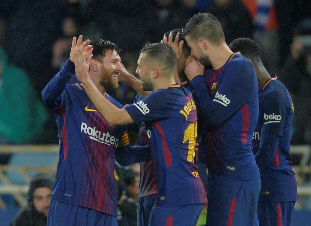 Barcelona’s Lionel Messi (L) celebrates with teammates after scoring their fourth goal against Real Sociedad at Anoeta Stadium, San Sebastian, Sunday. — Reuters