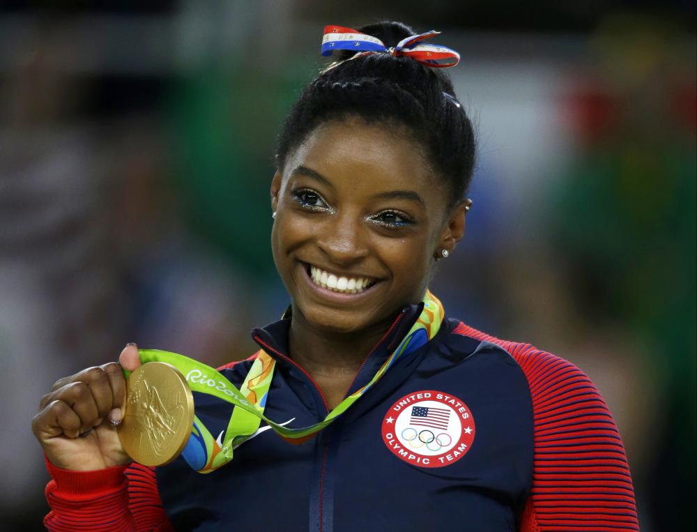 In this Aug. 16, 2016 file photo, US gymnast Simone Biles displays her gold medal for floor during the artistic gymnastics women’s apparatus final at the 2016 Summer Olympics in Rio de Janeiro. — AP 