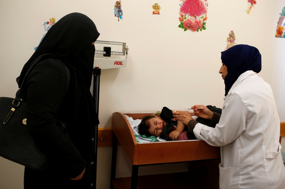 A Palestinian child is vaccinated at a United Nations-run clinic in Al-Shati refugee camp in Gaza City. — Reuters