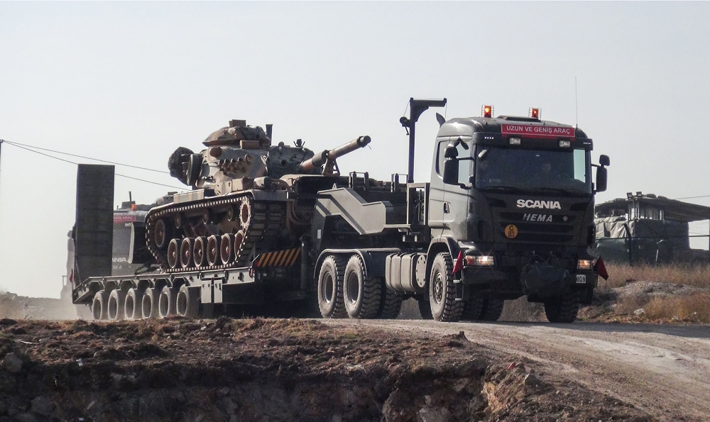 A photo made available by the Dogan New Agency shows Turkish army military trucks transporting armoured vehicles to reinforce the border units in Sanliurfa close to the Syrian border. — AFP