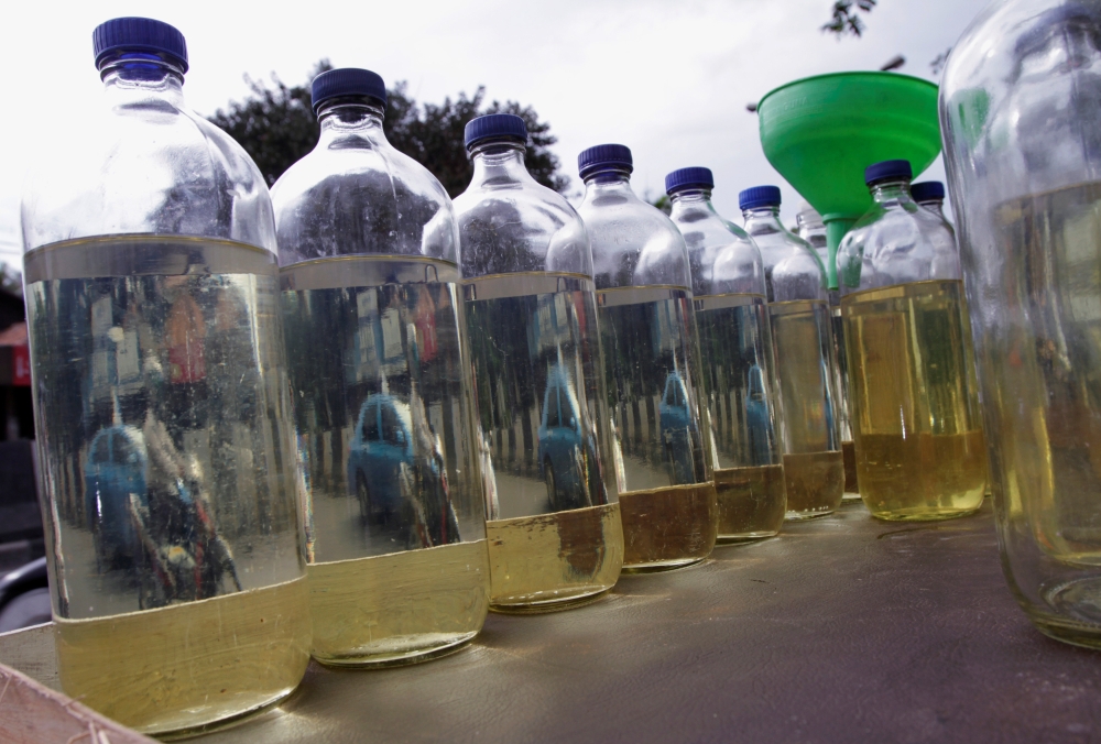 Bottles of gasoline are displayed for sale to motorists on a Jakarta street. — Reuters photos