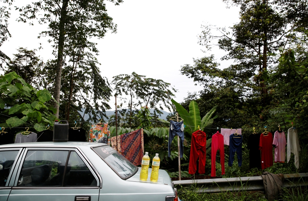 Bottles of gasoline are displayed for sale to motorists on a Jakarta street. — Reuters photos