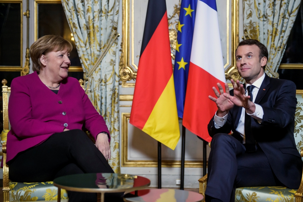 French President Emmanuel Macron and German Chancellor Angela Merkel react during their meeting at the Elysee Palace in Paris, France, Friday. — Reuters