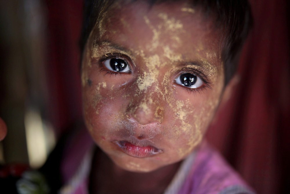A Rohingya girl reacts to the camera as she applies makeup in Balukhali refugee camp in Cox's Bazar, Bangladesh, Saturday. — Reuters