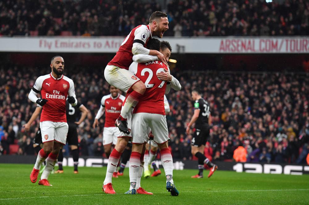 Arsenal's defender Laurent Koscielny (R) celebrates with teammates after scoring against Crystal Palace during their English Premier League football match at the Emirates Stadium in London Saturday. — AFP