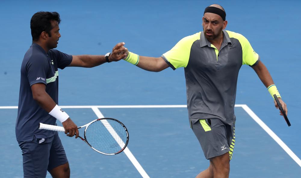 India's Leander Paes (L) and Purav Raja celebrate a point against Britain's Jamie Murray and Brazil's Bruno Soares during their doubles match at the Australian Open in Melbourne Saturday. — AP