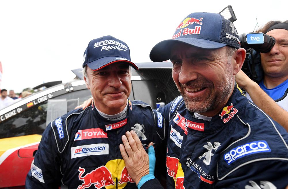 Peugeot's Spanish driver Carlos Sainz (L) is congratulated by his teammate French driver Stephane Peterhansel, after winning the Dakar Rally 2018 in Argentina Saturday. — AFP