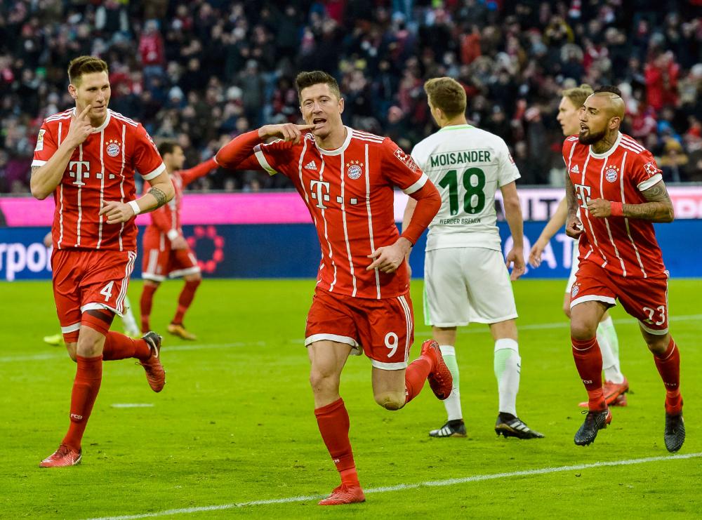 Bayern Munich's Robert Lewandowski (C) celebrates after scoring a goal during their German first division Bundesliga football match against Werder Bremen in Munich Sunday. — AFP