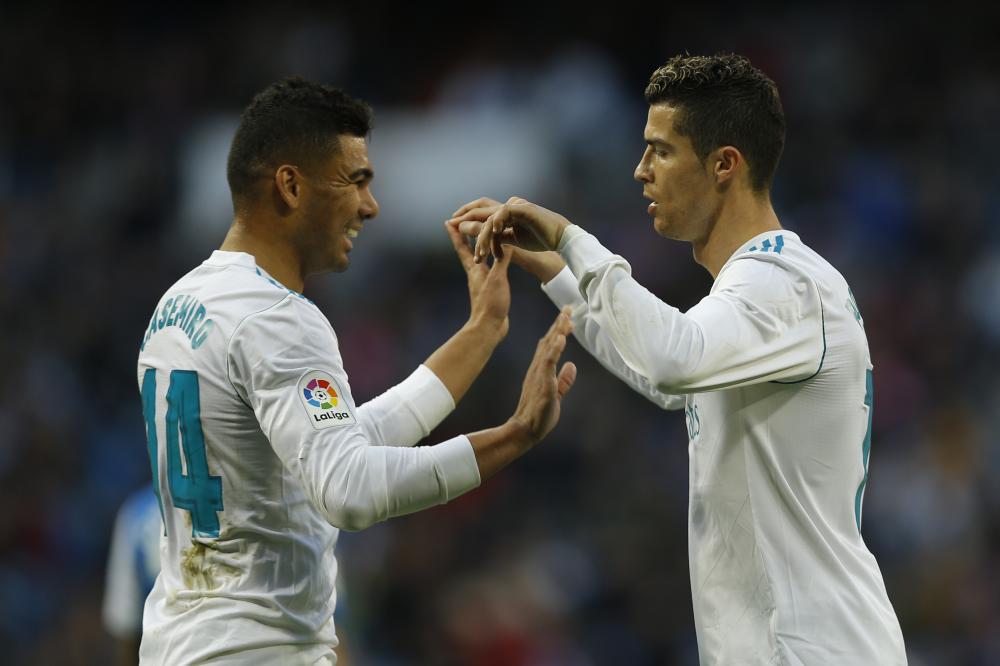 Real Madrid's Cristiano Ronaldo (R) celebrates with teammate Casemiro after scoring his side's fifth goal against Deportivo Coruna during their Spanish La Liga soccer match at the Santiago Bernabeu Stadium in Madrid Sunday. — AP 