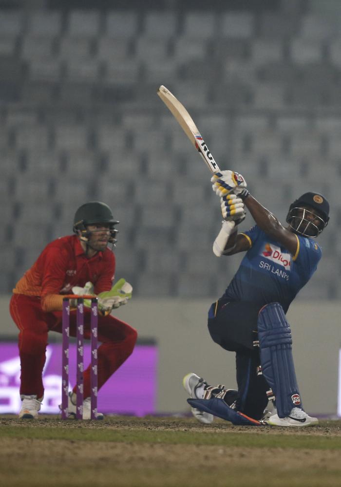 Sri Lanka's Thisara Perera plays a shot, as Zimbabwe's wicketkeeper Ryan Murray watches during the Tri-Nation One-Day International cricket series in Dhaka Sunday. — AP 