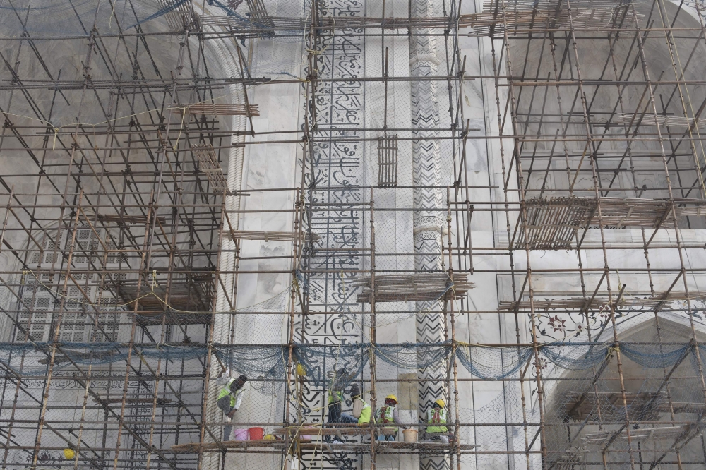 In this photograph taken on Jan. 3, 2018, Indian laborers work amid scaffolding during conservation work at the Taj Mahal in Agra. Restoration work at India's most popular tourist attraction has been dragging on for years, blighting views for tourists, but authorities have not even begun work on the unmissable centerpiece of the 17th-century icon - its imposing dome. - AFP