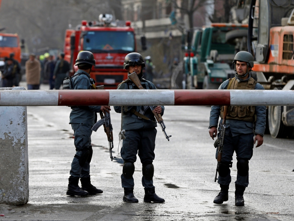 Afghan police keep watch at the site of a car bomb attack in Kabul, Afghanistan, on Saturday. — Reuters