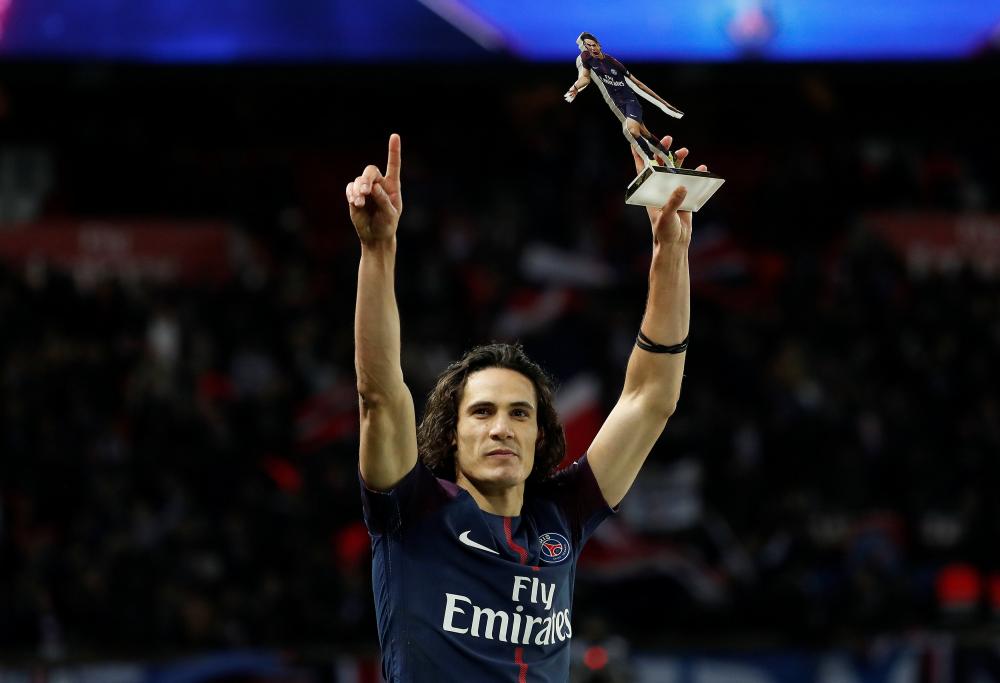 Paris Saint-Germain’s Edinson Cavani celebrates with a trophy becoming the club's all time top goal scorer at the end of the match against Montpellier at Parc des Princes, Paris, Saturday. — Reuters