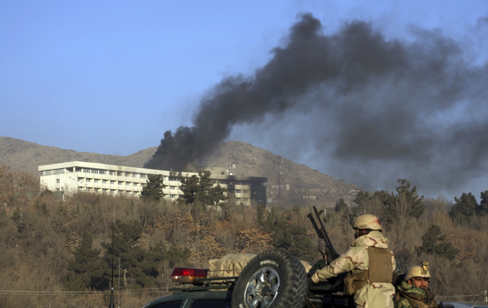 Afghan security personnel stand guard as black smoke rises from the Intercontinental Hotel after an attack in Kabul in this Jan. 21, 2018 file photo. — AP