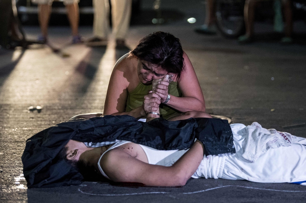 Nanette Castillo grieves next to the body of her son Aldrin, an alleged drug user killed by unidentified assailants in Manila in this Oct. 3, 2017 file photo. — AFP