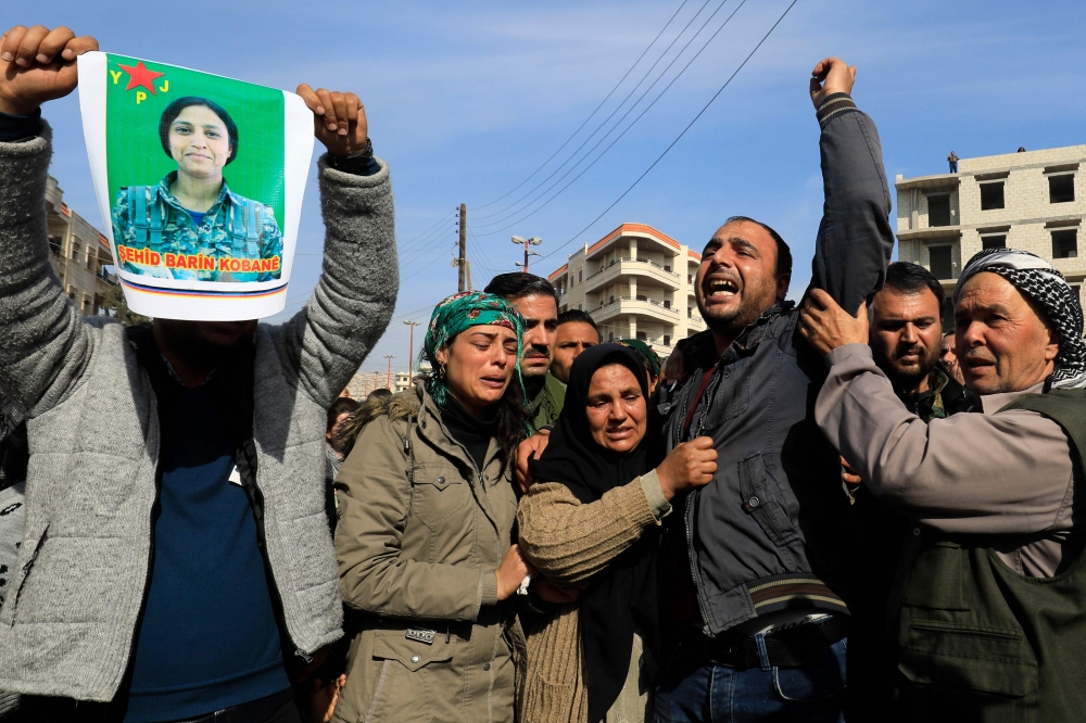 A picture taken on Saturday in the town of Afrin shows the mother (3rd-L), sister (2nd-L) and brother (C) of the late 23-year-old YPJ fighter Barin Kobani, chanting slogans during a mourning ceremony in her honor, after the YPJ and the Syrian Observatory for Human Rights accused Turkish-backed Syrian rebels of filming her mutilated dead body. — AFP