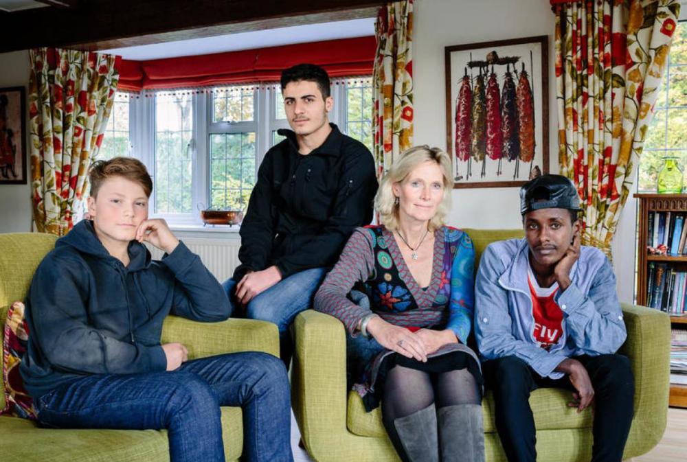 Ingrid Van Loo Plowman and her youngest son Ross, who host three refugees in their home in Epsom, near London, pose in this portrait exhibited in Feb. 2017 as part of Great British Welcome, an exposition at London's St Martin-in-the-Fields church. - Thomson Reuters Foundation