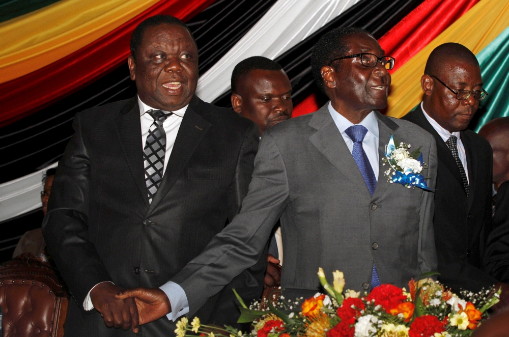 Zimbabwe’s President Robert Mugabe, front right, and Prime Minister Morgan Tsvangirai, left, attend a conference at a hotel in Harare in this Oct. 22, 2012 file photo. — Reuters