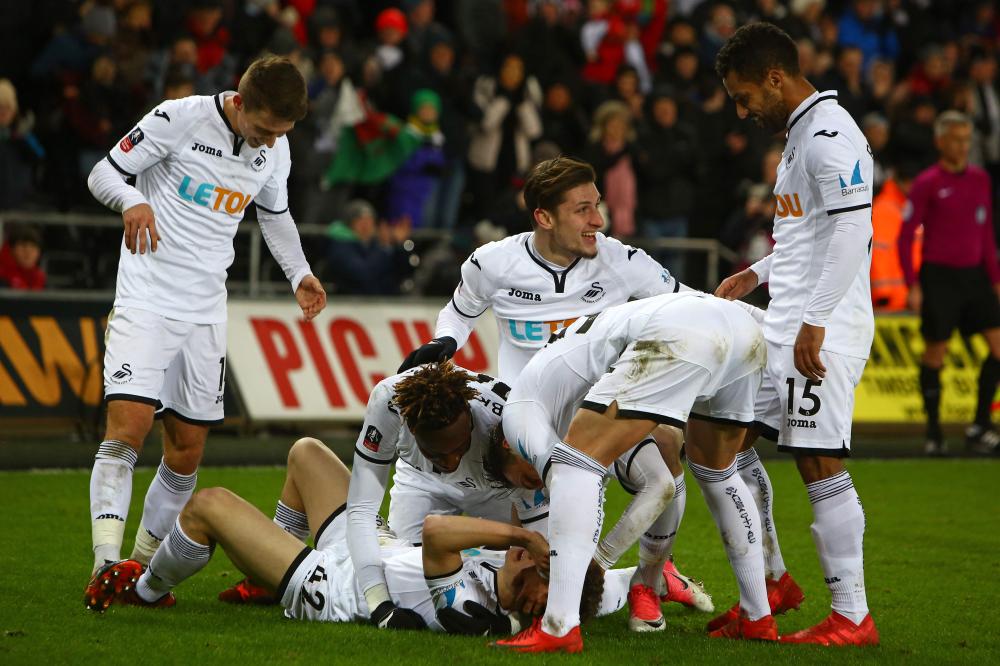 Swansea City’s midfielder Daniel James (on the ground) celebrates with teammates after scoring their eighth goal during their English FA Cup match against Notts County at The Liberty Stadium in Swansea Tuesday. — AFP