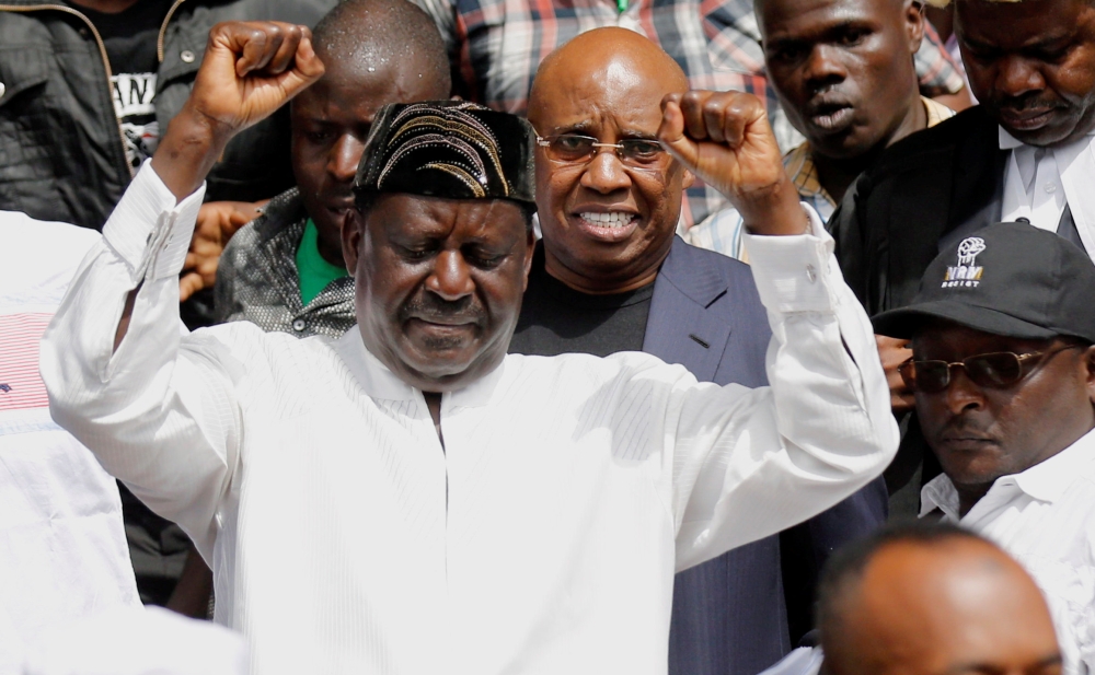 Kenyan opposition leader Raila Odinga of NASA coalition, escorted by businessman Jimi Wanjigi, gestures during a swearing-in ceremony as the president of the People’s Assembly in Nairobi, Kenya, in this Jan. 30, 2018 file photo. — Reuters