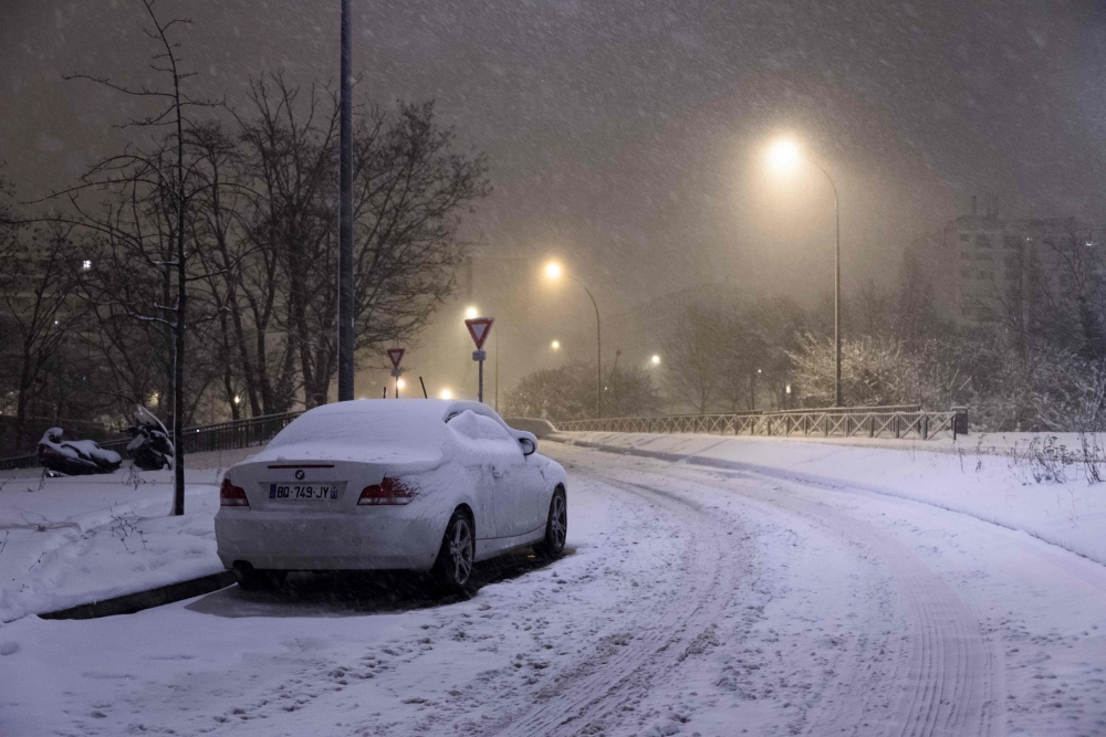 A snow-covered car was parked on the road, in Velizy-Villacoublay, southwestern suburbs of Paris, early Wednesday, after heavy overnight snowfall in northern France. — AFP