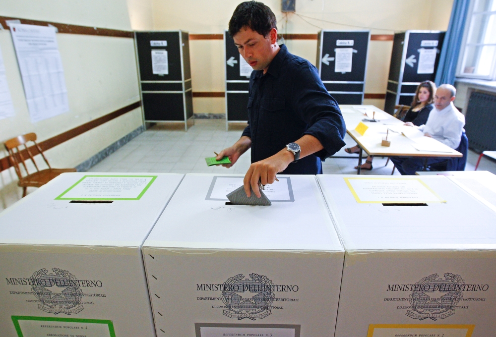 A man casts his ballot at a polling station in downtown Rome June 13, 2011. — Reuters
