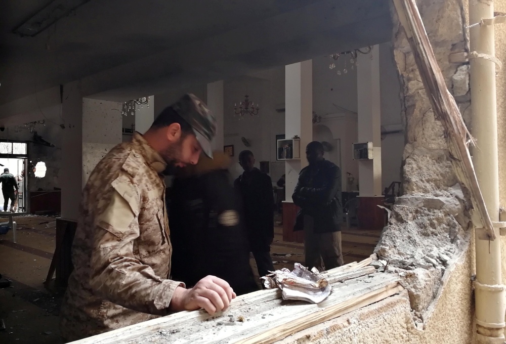 A member of the Libyan National Army inspects the damage following a twin bombing inside a mosque in Benghazi, Libya on Friday. — Reuters