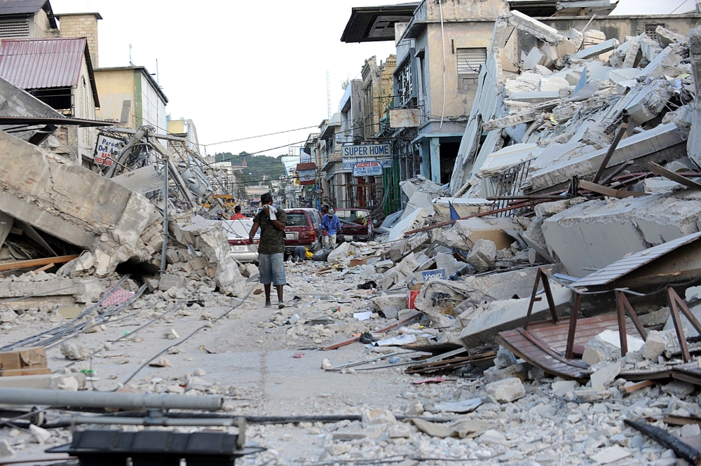 A man covers his face as he walks amid the rubble of a destroyed building in Port-au-Prince, Haiti, in this Jan. 14, 2010 file photo, following the devastating earthquake that rocked Haiti on Jan. 12. — AFP