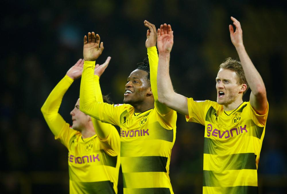 (L-R) Borussia Dortmund’s Mario Gotze, Michy Batshuayi and Andre Schurrle celebrate after their German football league match against Hamburger in Dortmund Saturday. — Reuters