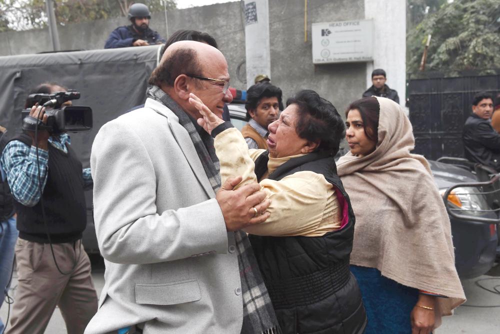 Pakistani mourners gather outside the home of human rights activist Asma Jehangir after the announcement of her death in Lahore on Sunday. — AFP