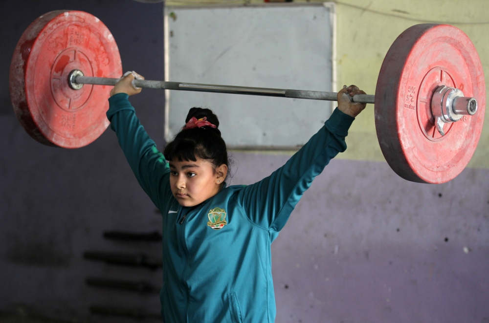 Iraqi weightlifter Roqaya Ahmed, 12, trains at a club in Sadr City, east of Baghdad. — AFP
