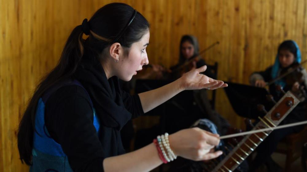 Negina Khpalwak, the first female orchestra conductor in Afghanistan, during a rehearsal at the Afghanistan National Institute of Music in Kabul . - AFP